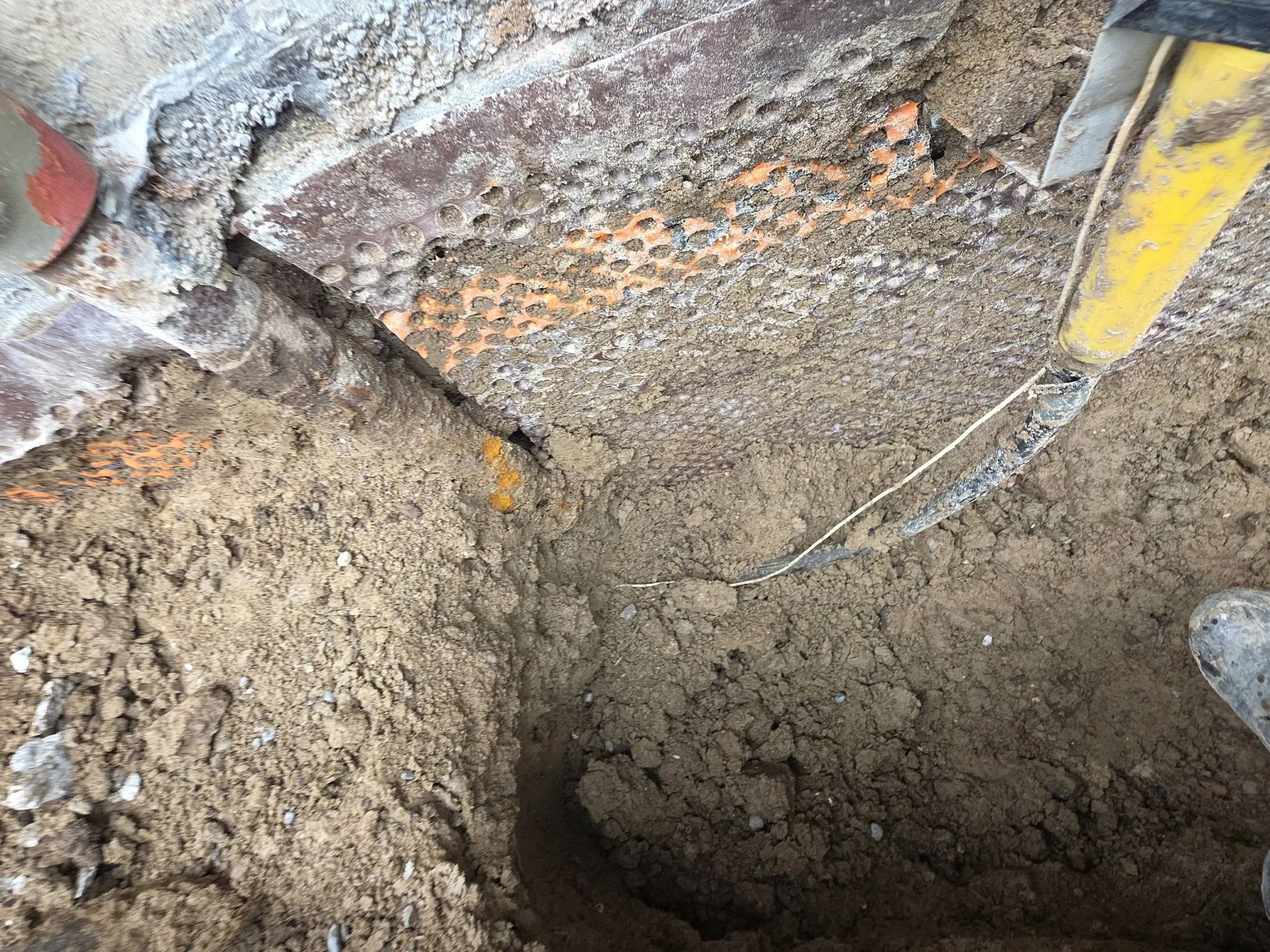 Excavation exposing the footing and original clay weeping tile of an older Toronto home