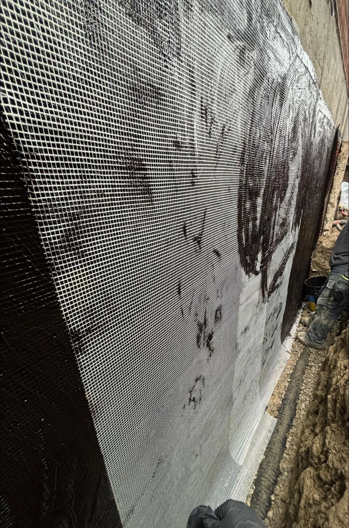 Exterior foundation wall coated with waterproofing membrane and dimple sheet in an open excavation, Toronto