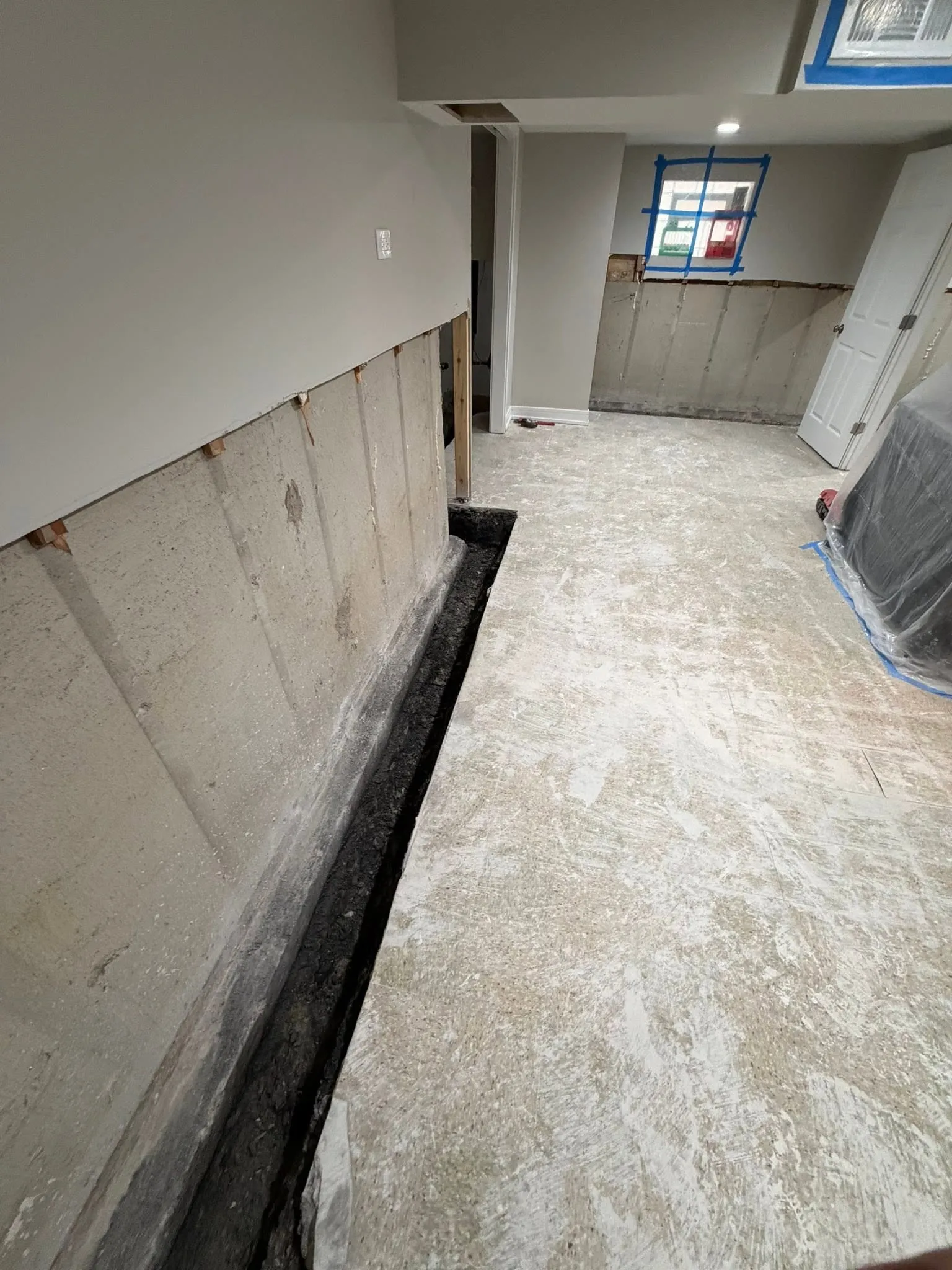 Interior drainage channel installed along the footing of a Toronto basement wall