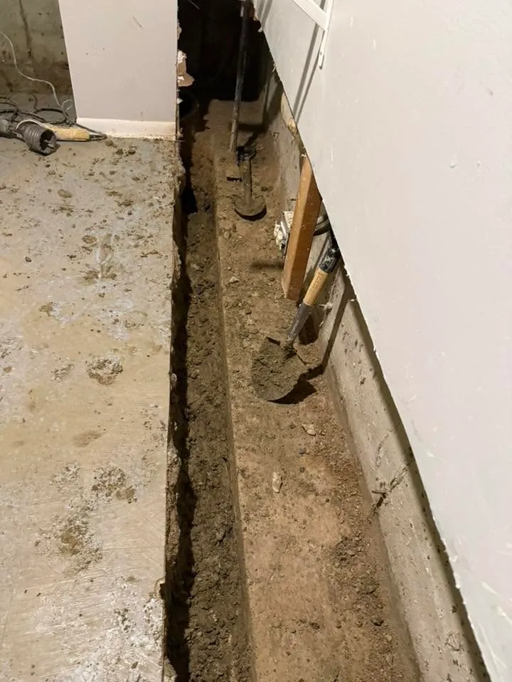 Interior perimeter trench cut through a basement slab exposing the footing