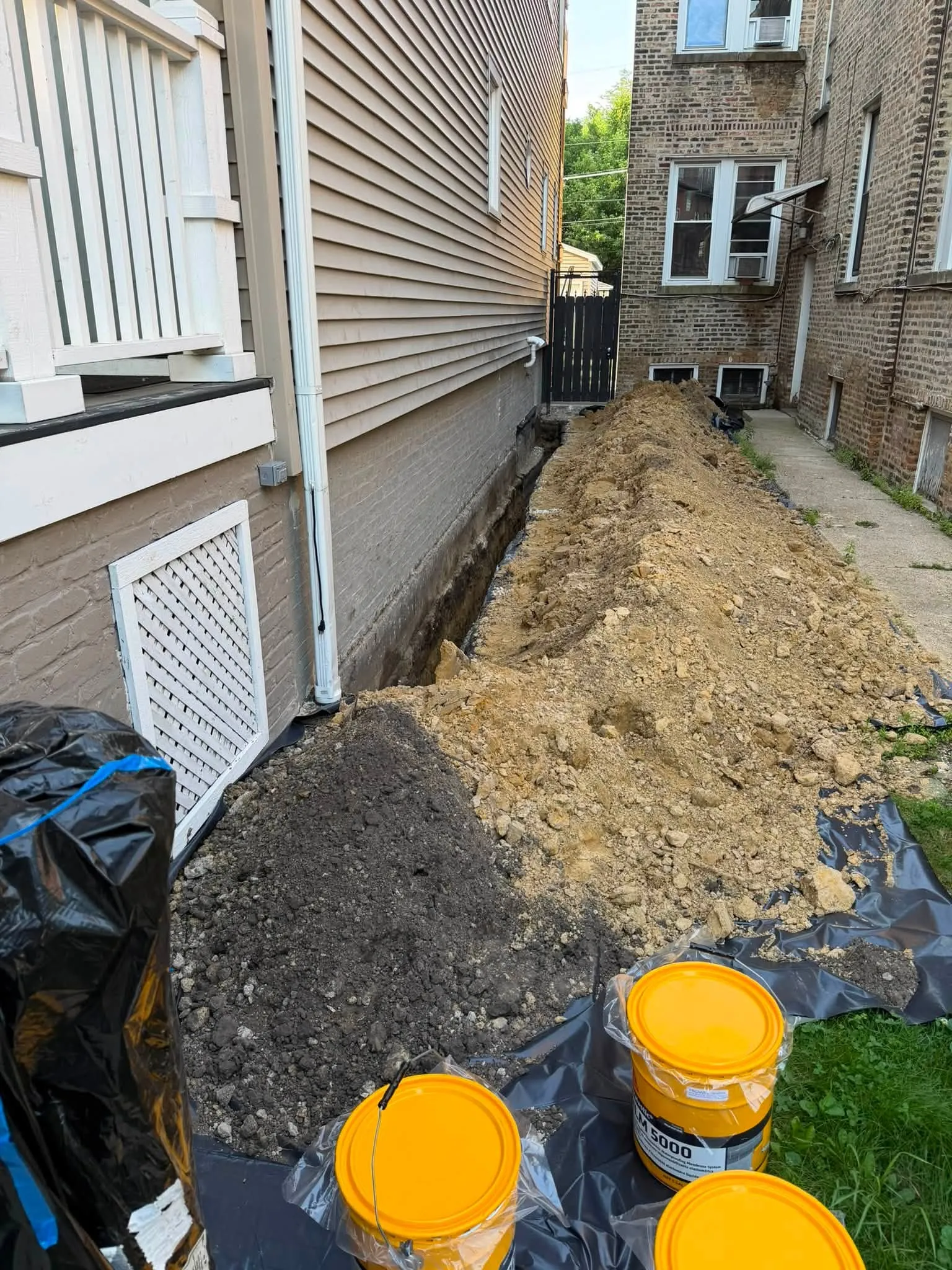 Excavation in a tight side yard between two semi-detached Toronto houses