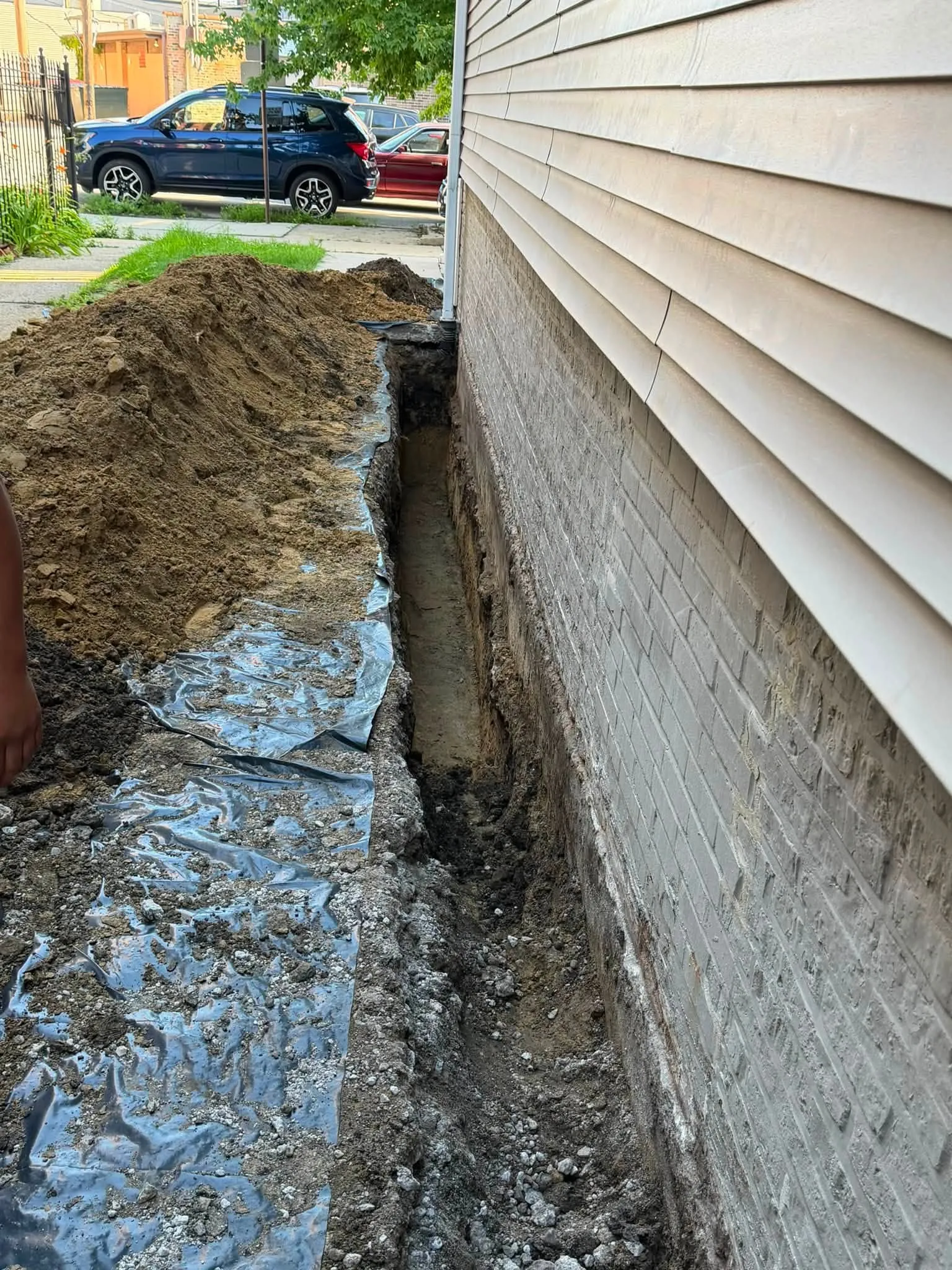 New perforated weeping tile laid at the footing in an open exterior trench